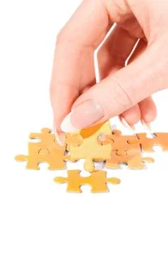 Putting right piece in puzzle Stock Photos