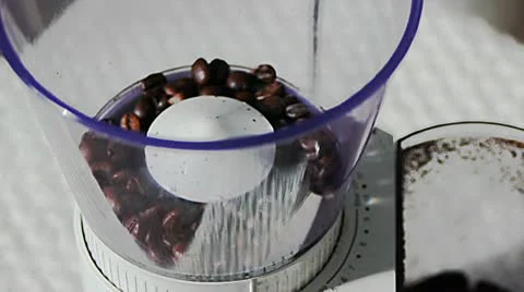 Putting roasted coffee beans to a coffee mill Stock Footage 10751350