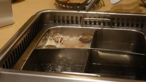 Putting salmon meat ball into boiling chinese hotpot suki stew soup steambo.. Stock-Footage 258351426