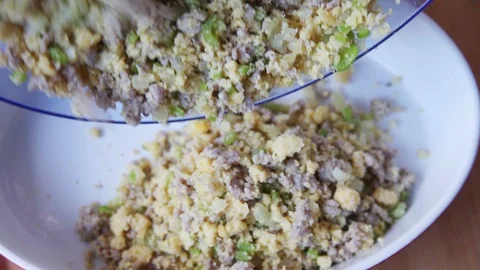 Putting sausage cornbread stuffing into dish Stock Footage 99406790