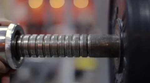 Putting Screw-On Collars on barbell slow motion Stock Footage 58515746