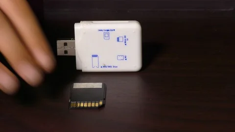 Putting SDHC card in reader on the table Stock Footage 128198709