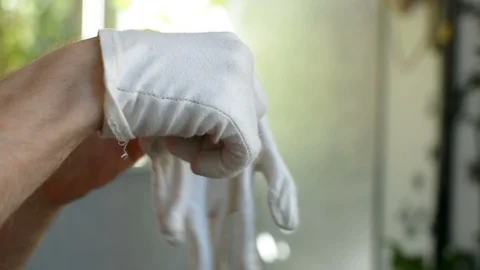 Putting on second left white cloth glove before working with plants and dirt 스톡 동영상 90847593