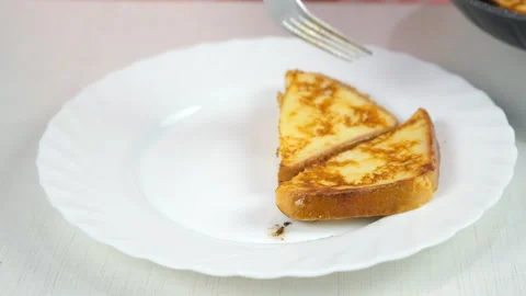 Putting serving frying bread slices on plate cooking toasts on kitchen at home. Stock-Footage 313134503