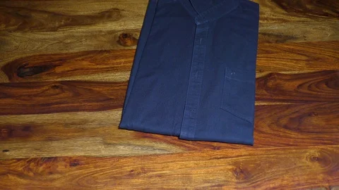 Putting shirts on the table and stacking them on each other Stock Footage 128198614