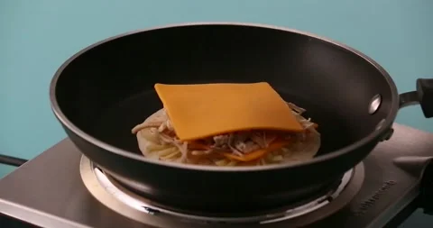 Putting shredded cheese on a slice of cheese, chicken, another slice of chee Stock-Footage 132203816