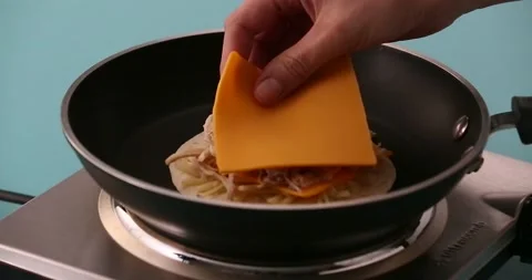 Putting a slice of cheese on chicken, sliced cheese, shredded cheese and a t Stock Footage 132203728