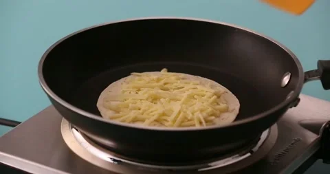 Putting a slice of cheese on shredded cheese and a tortilla 2 Stock Footage 132203690