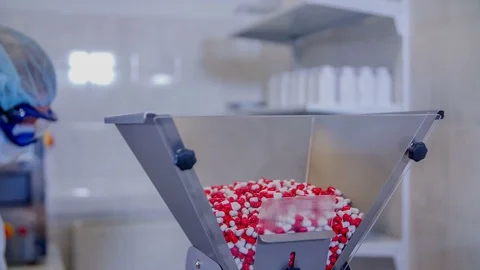 Putting a small shovel of pills inside a machine Video stock 71524094
