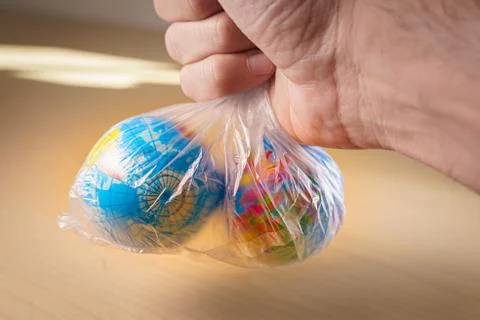 Putting small world globes inside a plastic bag Foto stock