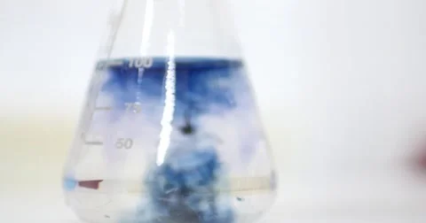 Putting some chemicals into an Erlenmeyer flask to check the water hardness Stock Footage 50928067