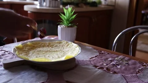 Putting some cherry jam on a pancake on a table in dining room by female Video stock 138452666