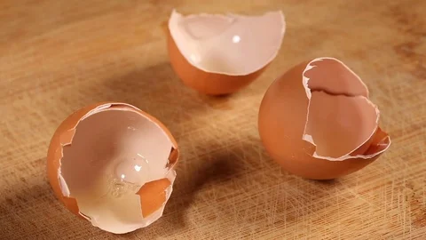 Putting some egg shells on wooden cutting board Stock Footage 83183024