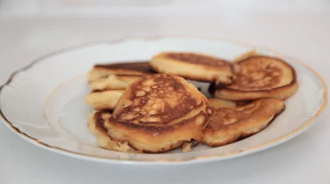 Putting some of the finished pancakes on a plate Stock-Footage 64732913