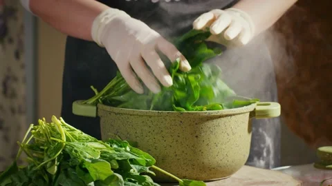 Putting spinach in a pan for boiling Stock Footage 138127273