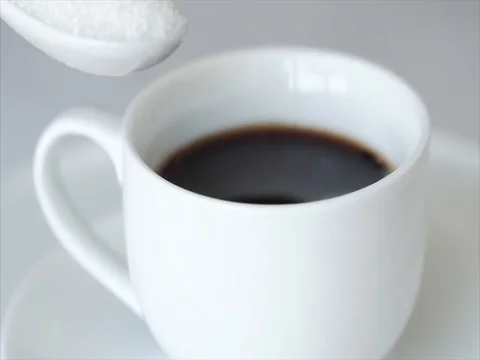 Putting spoon with sugar into hot coffee white cup Stock Footage 76509007