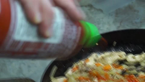 PUTTING SRIRACHA IN MEAL Stock Footage