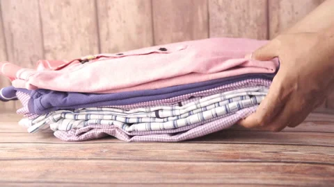 Putting stack of clothes on table . Stock Footage 150635043