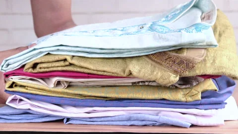 Putting stack of cloths on table. Stock Footage 149873834