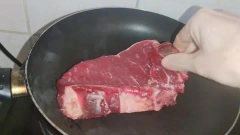 Putting a steak in the frying pan 動画素材 241691764