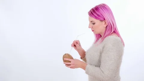 Putting a straw into the coconut and drinking from it Stock Footage 83724562