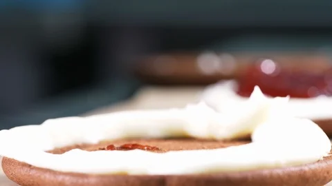 Putting a strawberry jam in the middle of small chocolate cake. Stock Footage 108266897