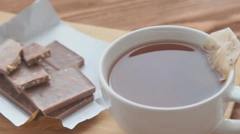 Putting sugar and tea bag in a glass mug with hot water Stock Footage 68974495