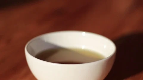 Putting sugar into a cup of green tea Video stock 70943365