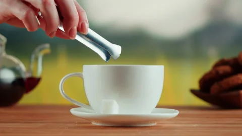 Putting sugar into white cup close-up. Freshly brewed hot tea or sweet coffee Stock Footage 191094921