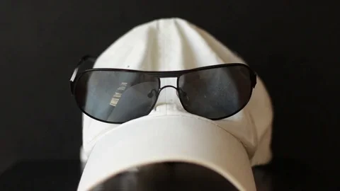 Putting sunglasses on the white cap Stock Footage 77178213