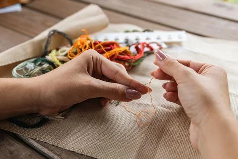 Putting the thread through the eye of the needle. Close-up of the cross sti.. Stock Photos