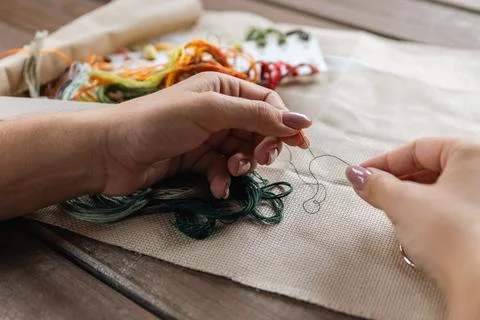 Putting the thread through the eye of the needle. Close-up of the cross sti.. Stock Photos
