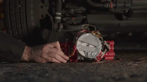Putting time bomb under car Stock Footage 144872583