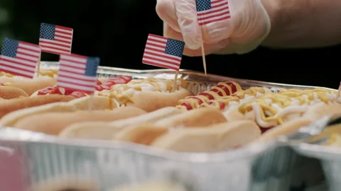 Putting Tiny USA Flags on Hot Dogs for Independence Day Stock Footage 133598310