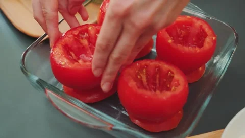 Putting the tomato in a baking dish Video stock 250409661