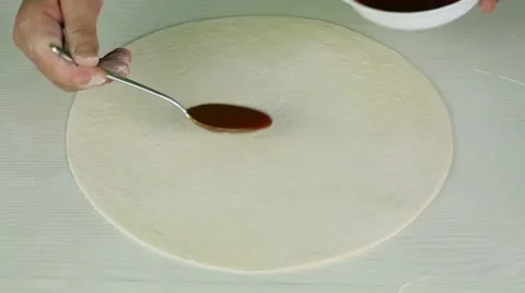 Putting tomato sauce on dough Stock Footage 52487639