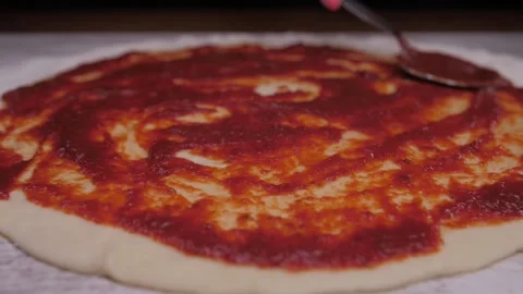 Putting tomato sauce in pizza Stock Footage 150458147