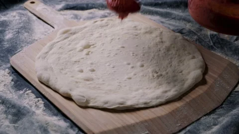 Putting tomato sauce on spread out sourdough Stock Footage 132842346