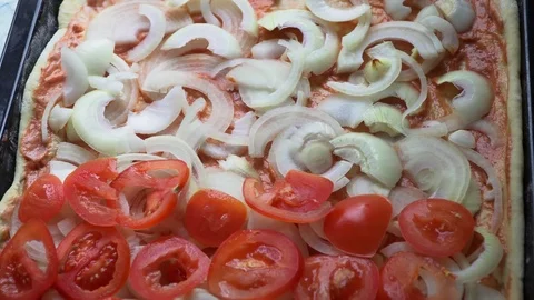 Putting tomatoes on pizza dough Stock Footage 84100477