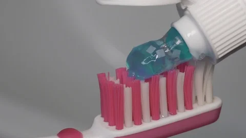 Putting toothpaste with granules on toothbrush. Close up Stock Footage 97708454