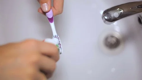 Putting toothpaste on toothbrush Stock Footage
