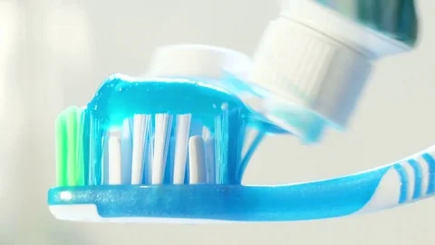 Putting toothpaste on a toothbrush Stock Footage 85379416