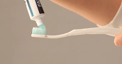 Putting tootpaste on a toothbrush Stock Footage 97260477