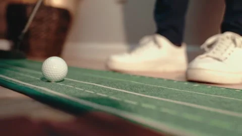 Putting Trainer Slow Motion Single Ball White Sneakers Practice Setup Wood Video stock 334490507