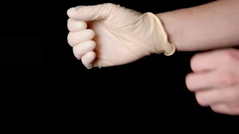 Putting on two disposable gloves in professional studio black background Stock Footage 147527583