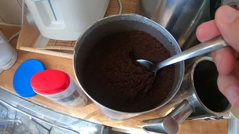Putting Two Spoons of Ground Coffee in A Coffee Pot Stock Footage 137826363