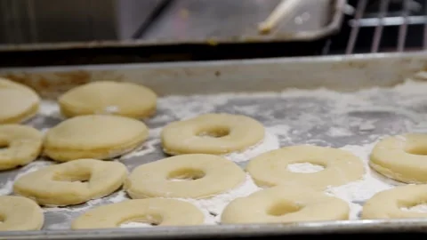 Putting the uncooked donuts into the oven Stock Footage 307339986
