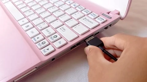Putting usb cable into a pink laptop Stock Footage 145623439