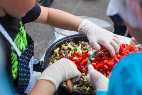 Putting vegetables in a pan Stock Photos