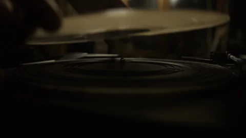 Putting vinyl record on turntable and putting stylus needle on Stock Footage 129573576